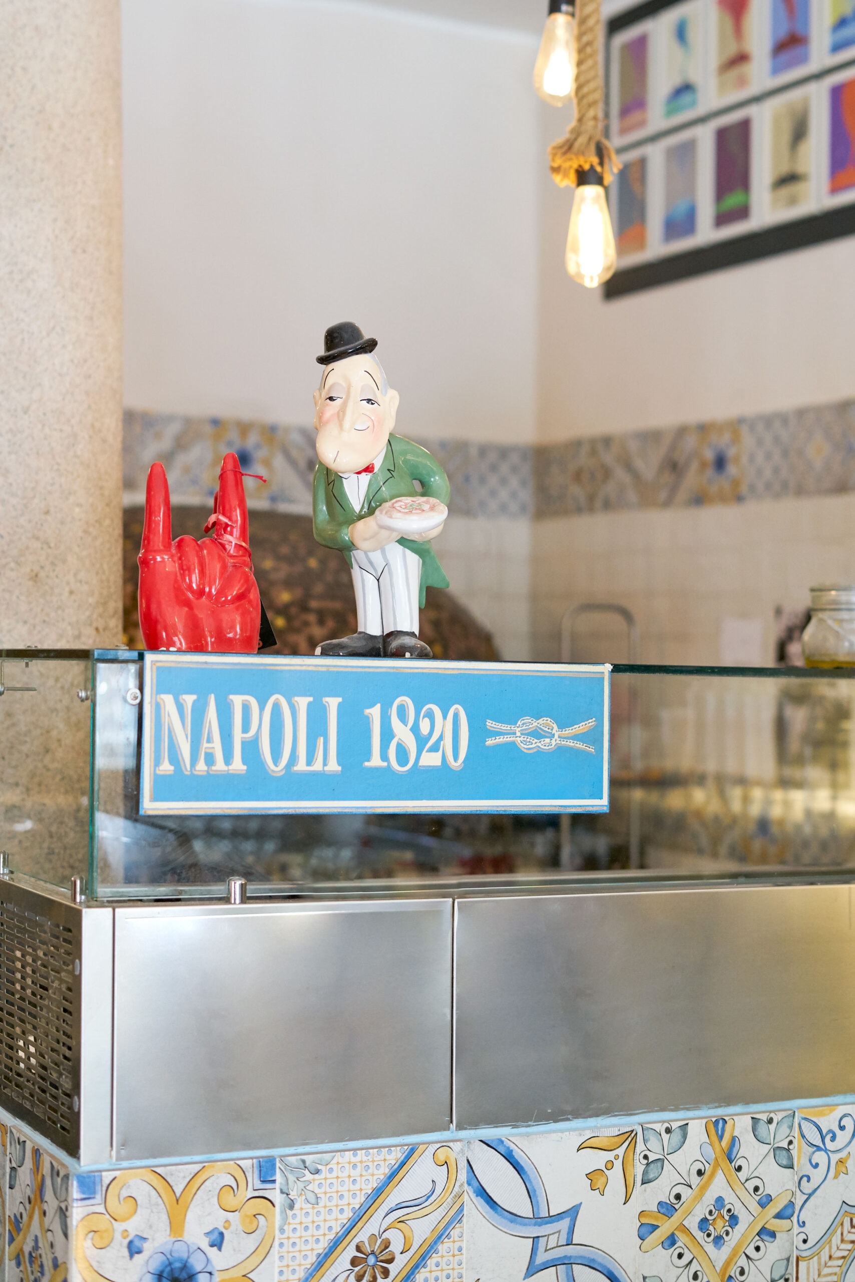 Bancone con insegna Napoli 1820 e statuina — dettaglio d'atmosfera del locale