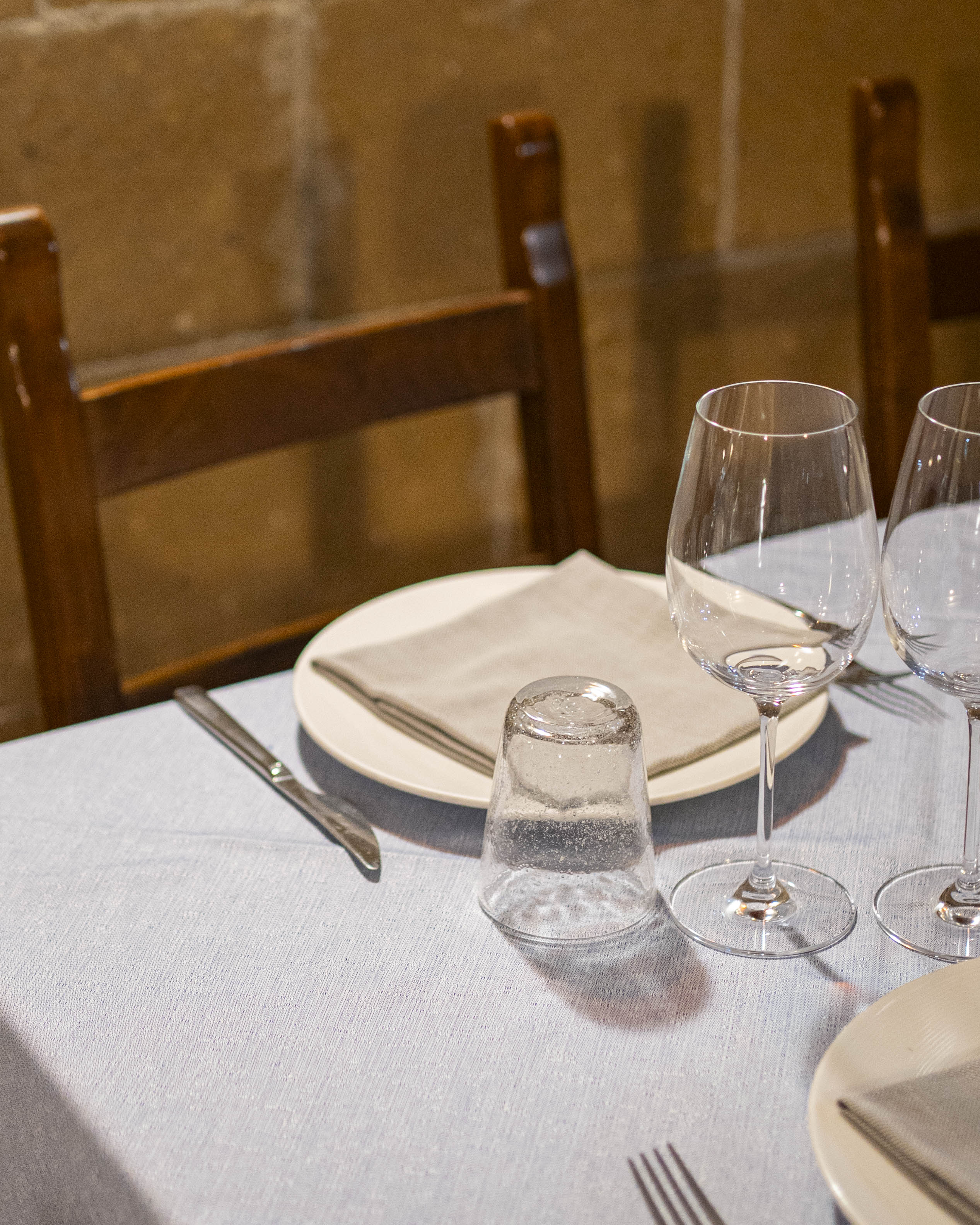 Mise en place con piatti, bicchieri e tessuti sulla tavola